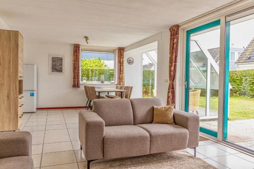 - un salon avec un canapé et une table dans l'établissement Bohemien Resort 8, à Sint Maartensvlotbrug