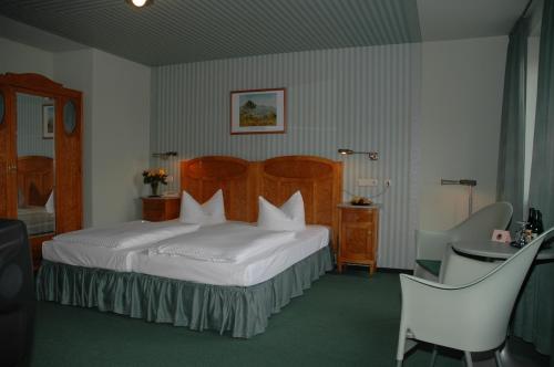 una camera d'albergo con letto, tavolo e sedie di Hotel Goldener Anker a Radebeul