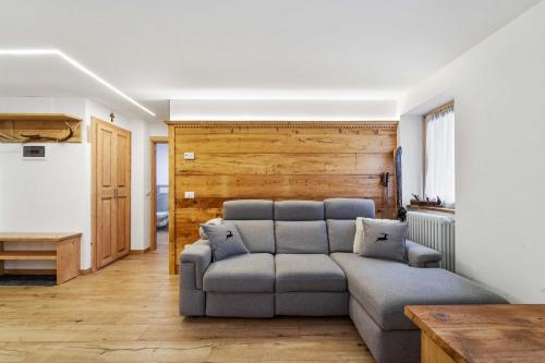 ein Wohnzimmer mit einem Sofa und einer Holzwand in der Unterkunft Casa Graziosa in Campodolcino