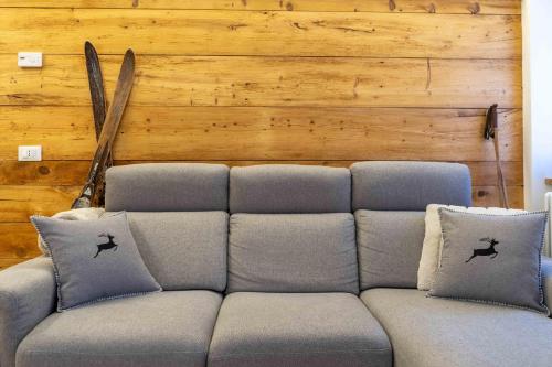 ein Sofa in einem Zimmer mit einer Holzwand in der Unterkunft Casa Graziosa in Campodolcino