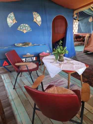 Zimmer mit einem Tisch und Stühlen sowie einem blauen Zelt in der Unterkunft Nomads House in Bled