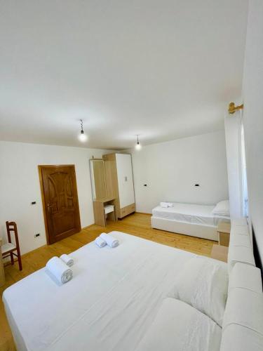 a bedroom with two beds and a wooden floor at Mountain Oasis in Valbonë