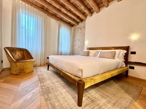 1 dormitorio con 1 cama grande y 1 silla en Palazzo CarpeDiem-Prato della Valle, en Padua