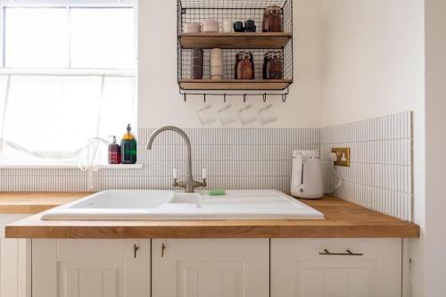cocina blanca con fregadero y ventana en no.five Flushing, en Flushing
