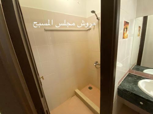 ein Bad mit einer Dusche, einem Waschbecken und einem Spiegel in der Unterkunft Al Ahlam Island Villa Durrat AlArous فيلا جزيرة الأحلام درة العروس in Durrat Al-Arus