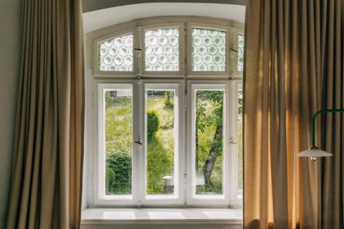 een raam in een kamer met uitzicht op een tuin bij Blyb Hotel in Gmund am Tegernsee