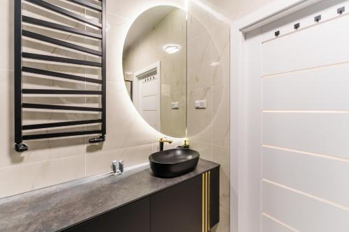 een badkamer met een zwarte wastafel en een spiegel bij Apartament Eco Modern III by HolidaySun in Sianozety