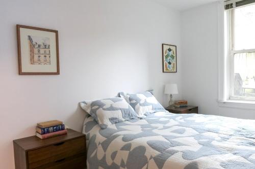um quarto branco com uma cama e uma janela em Garden Guest Suite em Brooklyn