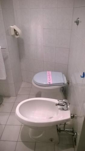 y baño con aseo blanco y lavamanos. en Appartamenti Roberta Cisanello 2, en Pisa