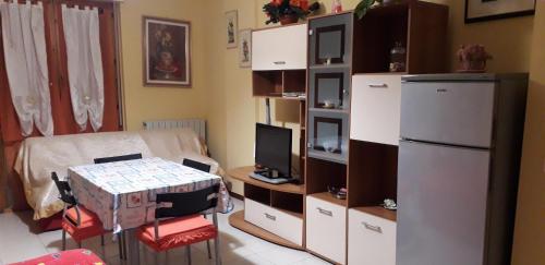Zimmer mit einem Kühlschrank und einem Tisch mit einem TV. in der Unterkunft Appartamenti Roberta Cisanello 2 in Pisa