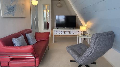 a living room with a couch and a tv at Slapen aan het IJsselmeer - with SEAVIEW and SUNSET in Stavoren