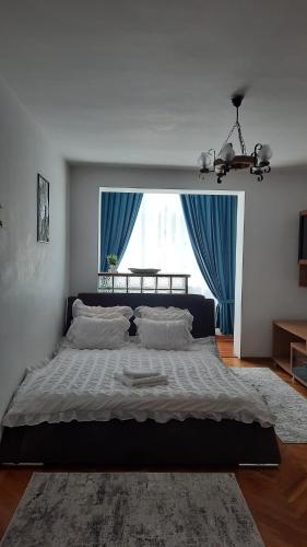 um quarto com uma cama grande e uma janela grande em Apartament Centru em Cugir