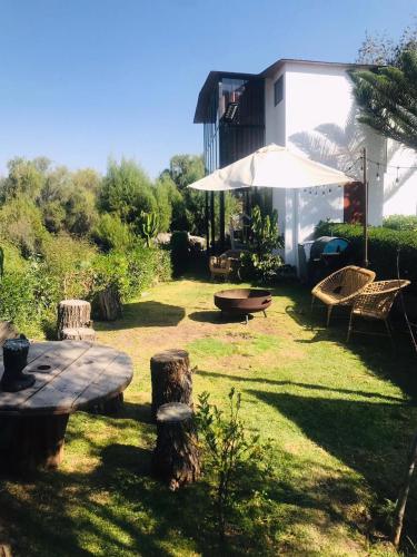 a backyard with a table and chairs and an umbrella at Cabaña vista al rio in Arequipa