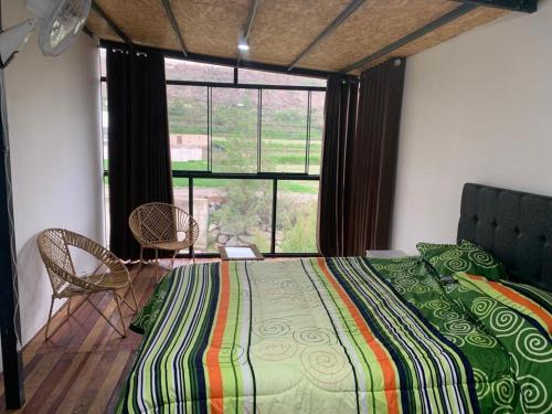 a bedroom with a bed and a large window at Cabaña vista al rio in Arequipa