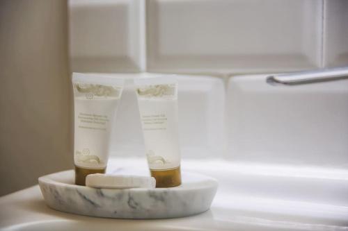 un comptoir avec deux bouteilles d'hydratants et de savon dans l'établissement LE PETIT MORNY. Apt rénové lumineux et central, à Deauville