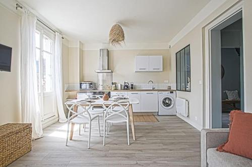 une cuisine avec une table et des chaises dans une pièce dans l'établissement LE PETIT MORNY. Apt rénové lumineux et central, à Deauville