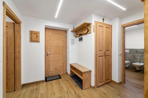 a bathroom with a wooden door and a toilet at Casa Graziosa in Campodolcino