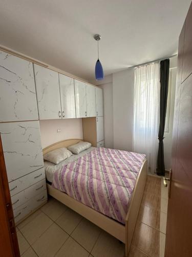 una camera con letto e armadi bianchi di Paradise apartman a Durrës