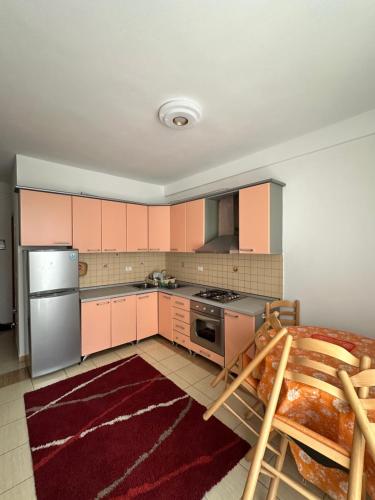 una cucina con armadietti rosa e frigorifero in acciaio inossidabile di Paradise apartman a Durrës