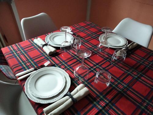 a table with plates and wine glasses on it at appartamento signorile con giardino in Aosta