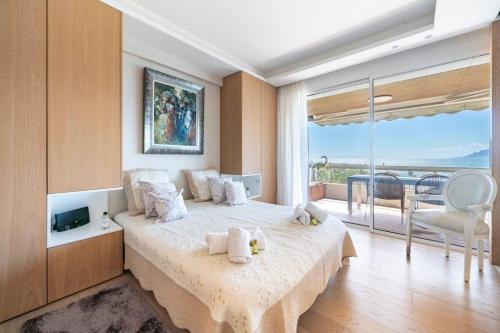 une chambre avec un grand lit et une grande fenêtre dans l'établissement Croisette Appartement vue mer 3 chambres, à Cannes