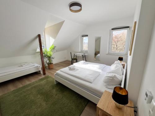 a white bedroom with a bed and a table at Villa Plassenburg in Kulmbach