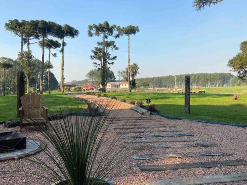 a stone walkway with a bench in a park at Cabana Fazenda Santa Inês - São Francisco de Paula in São Francisco de Paula