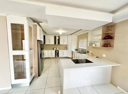 a kitchen with white cabinets and a white counter top at Coral Bliss in Walvis Bay