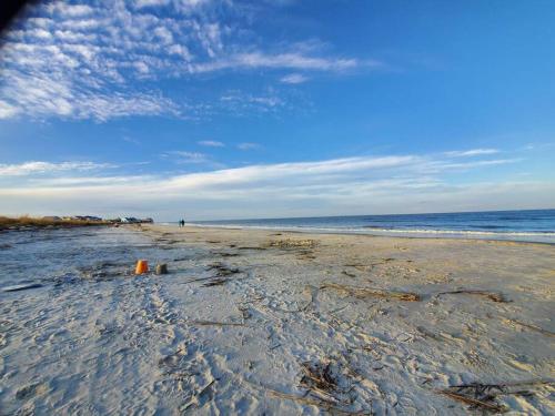 a sandy beach with a blue sky and the ocean at Beach condo on Harbor Island,SC E105 in Oceanmarsh Subdivision