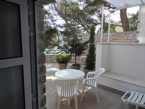 - une table et des chaises blanches sur la terrasse dans l'établissement Apartment Rosabela, à Primošten