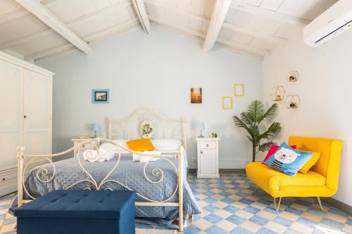 - une chambre avec un lit et une chaise jaune dans l'établissement La Casa del Pescatore - Lake Trasimeno's Retreat, à San Feliciano