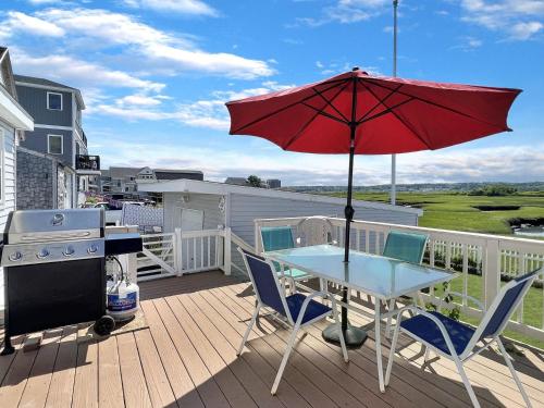 a patio table with a red umbrella on a deck at Sweet Dreams W032 Brought to you by GetAway Vacations in Wells