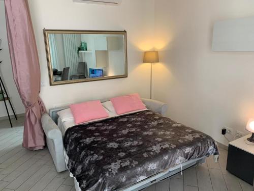 Schlafzimmer mit einem Bett und einem Spiegel an der Wand in der Unterkunft Appartamento l'Incanto in Rom