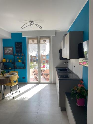 a kitchen with blue walls and a table and a dining room at Casaluisa in Genova