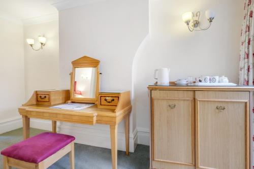 a wooden desk with a mirror and a stool at Charles House - Windsor Castle in Windsor