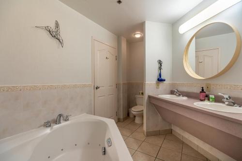 bagno con vasca, 2 lavandini e specchio di Urban Nest, 1-BDRM Apt, Ground Floor a Halifax