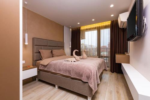 um quarto com uma cama e uma televisão de ecrã plano em Central Victoria Home 2-bedroom apt em Plovdiv