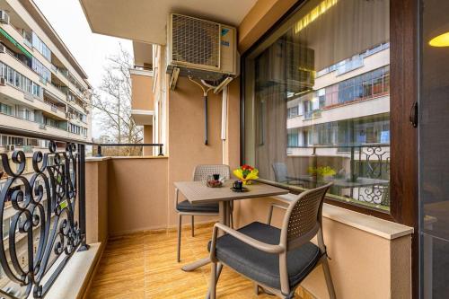 uma varanda com uma mesa e cadeiras. em Central Victoria Home 2-bedroom apt em Plovdiv