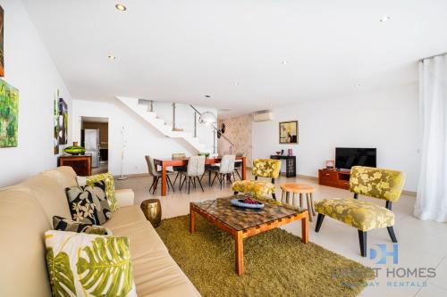 sala de estar con sofá, sillas y mesa en Villas Rocha, en Albufeira