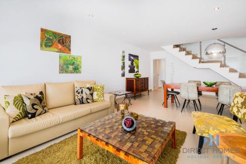a living room with a couch and a table at Villas Rocha in Albufeira