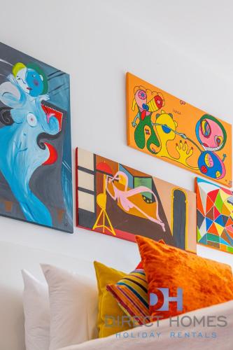 three pieces of art on a wall above a couch at Villas Rocha in Albufeira