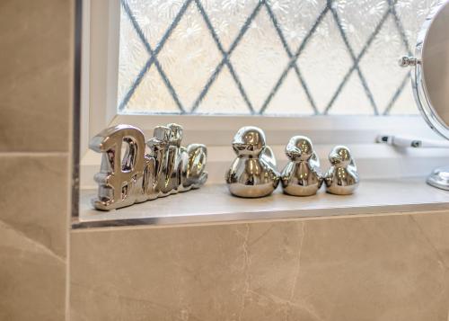 a group of silver bells sitting on a shelf in a bathroom at Modern House w/Terrace in Nottingham FREE Parking in Nottingham