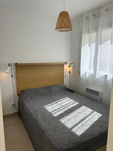 une chambre avec un grand lit et une fenêtre dans l'établissement Bravone 74- piscine en résidence-clim-wifi-pieds dans l'eau, à Linguizzetta