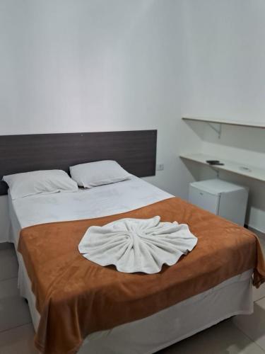 um quarto com uma cama com uma toalha em Hotel Araçariguama em Araçariguama