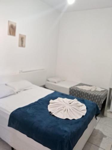 2 camas en un dormitorio con una toalla en la cama en Hotel Araçariguama en Araçariguama