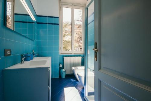 een blauwe badkamer met een wastafel en een toilet bij The Queen's Suite - Villa Candela in Stresa