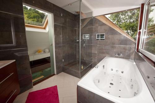 a large bathroom with a tub and a shower at Chalet Stahl - Ferienhaus mit Pool in Freiburg im Breisgau