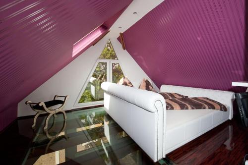 a bedroom with a white couch and a purple wall at Chalet Stahl - Ferienhaus mit Pool in Freiburg im Breisgau
