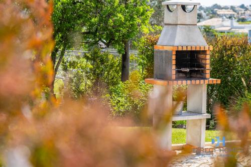 a small brick oven sitting in a garden at Villas Rocha in Albufeira