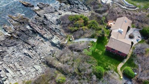 una vista aérea de una casa en una colina junto al agua en Seacoast Sanctuary Brought to you by GetAway Vacations, en Cape Neddick
